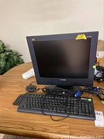 Black ViewSonic 17-inch LCD monitor with Inland keyboard and accompanying cables on a wooden table.