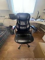 Front view of black office chair showing cushioned seat and backrest, armrests, and casters.