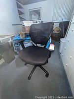 Front view of black mesh office chair showing padded seat, mesh backrest, and caster wheels.