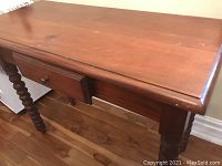 Front top and drawer view showing the smooth teak wood surface with wear, including a burn and dents, and two drawers with knobs.