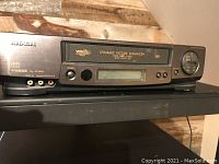 Front and top view of the Hitachi FX633 VCR showing the cassette door with 'Dynamic Picture Enhancer' and control buttons.