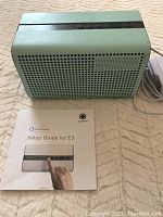 Top front view of GGMM E3 smart speaker showing perforated speaker grills and accompanying setup guide.