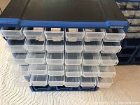 Front side showing 24 small transparent plastic bins in black frame with blue Mastercraft header.