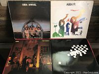 Four ABBA vinyl records and Chess soundtrack album laid out on surface.