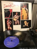 Front of vinyl sleeve showing multiple colored photos of David Bowie during live performances with record partially visible.