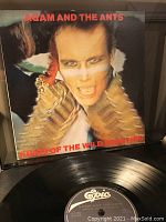 Front cover of the album featuring lead singer in costume and vinyl record showing Epic label.