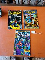Three comics (#194, #206, #180) laid out on table showing front covers