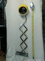 Photo of light fixture fully extended with measuring tape showing length approximately 24 inches.