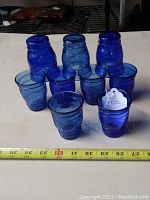 Ten cobalt blue shot glasses arranged in group, showing overall size and shape. Glasses have a simple embossed ring pattern around the body.