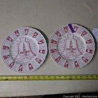 Two Liberty Bell 'Let Freedom Ring' astrology plates with astrological year calendar around the rim, burgundy decoration on white ceramic.
