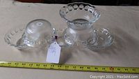 Two clear glass small serving bowls with scalloped and textured edges resembling apple shapes