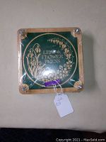 Top view of wooden flower press showing green panel with 'Leaf & Flower Press' text and floral design.