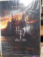 Full view of the Harry Potter Deathly Hallows Part 1 & 2 movie poster showing Hogwarts castle burning and 'It All Ends Here' tagline.