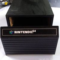 Top and front view showing black ridged plastic Nintendo 64 game cartridge case with logo