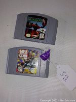 Two Nintendo 64 game cartridges lying on a white surface, one Starfox 64 and one NFL Quarterback Club 98