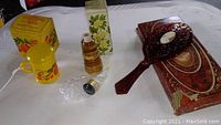 Photo showing Avon powder sachet container, cologne bottle, and cameo vanity mirror with original boxes.
