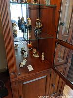 Porcelain figurines displayed on shelves including human figures and animals
