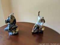 Photo of two of the Chinese fisherman figurines placed on a wooden table, showing poses and colors