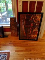 View showing two metal plaques leaning against the wall next to a large framed cityscape print titled 'The Temple Bar'.