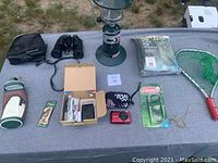 Wide shot of all items in lot displayed on a gray table outdoors.