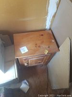 Pine side table showing top surface with scratches and wood knots