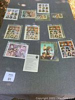 Full overview of multiple Beatles and John Lennon stamp sheets laid out on a table
