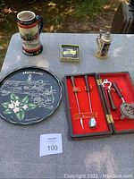 Wide view of all items on table including beer steins, tray, coasters, cocktail set, ice bucket
