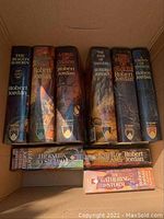 Eight Robert Jordan hardcover books in a cardboard box, spines are visible showing titles and author.