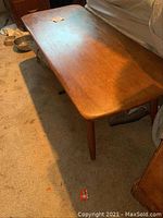 Wooden bench showing top surface and side with scratches and worn finish