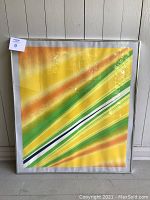 Full view of framed serigraph print leaning against wall