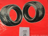 Close-up of the two black tires depicted on the red silkscreen surface, showing details of tread pattern and sharp black ink printing.