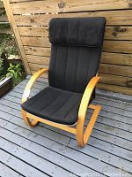 Side angle photo of the vintage Ikea lounger showing curved bentwood frame and black cushioned seat and headrest