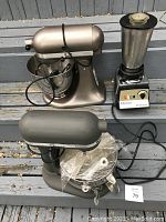 Front view showing both KitchenAid mixers and Osterizer blender on wooden steps