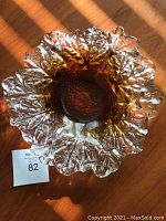 Top-down photo showing the clear glass bowl with an amber-toned center and intricate leaf-patterned edges.