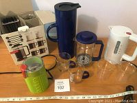 Full view of the coffee set items including the Stelton thermos, Bodum grinder, French press, electric kettle, and glasses arranged on a table with ruler for scale.
