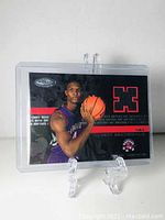 Front view of Chris Bosh 2003 rookie jersey card, showing player image and card details inside plastic holder.