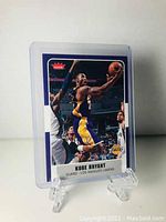 Front view of the 2007-08 Fleer Kobe Bryant basketball card, showing Kobe in action shooting over defenders.