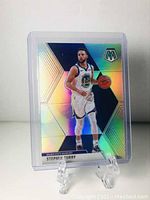 Stephen Curry holographic basketball card with mosaic background, in plastic protective sleeve displayed on clear stand