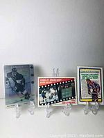 Three Wayne Gretzky hockey cards displayed on clear stands showing front faces.