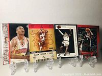 Four Allen Iverson basketball cards displayed on plastic card holders showing front images including Team USA uniform and Philadelphia 76ers action shots.