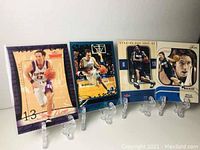 Four Steve Nash basketball cards arranged side by side on display stands. Two cards with Nash in Phoenix Suns jersey and two in Dallas Mavericks jersey. Various brands including Fleer and Flair.
