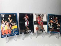 Four Scottie Pippen basketball cards displayed on clear plastic stands, two in Portland Trail Blazers uniform, two in Chicago Bulls, from Fleer and Upper Deck.