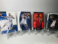 Wide shot of four Tracy McGrady basketball cards on display stands showing front designs, highlighting variety of styles and teams.