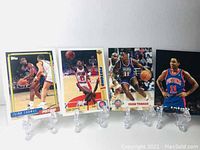 Four Isaiah Thomas basketball cards displayed on clear stands, showing front images with Pistons uniform and action shots.
