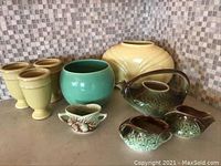 Entire lot showing one large yellow vase, green GMBC vessel, McCoy teapot and matching sugar and creamer, three yellow pedestal vases, small pottery bowl