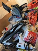 Craftsman 10-inch compound miter saw with dust bag and black and gray Craftsman 75th Anniversary tool bag along with orange extension cords, glue tool, and glue sticks.