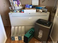 Overall organization of the Hon lateral file cabinet with office supplies arranged on top, shredder next to it, file folders and organizer baskets on the floor in front