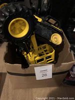 Box containing two Tonka graders with black and yellow color scheme. One grader blade missing.