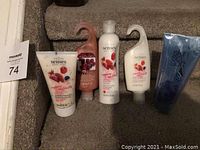 Full set of Avon personal care products including shower gels, body lotion, exfoliating body scrub, and shave gel displayed on carpeted stairs.
