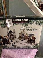 Box of Kirkland Signature 20-piece Lighted Victorian Village set showing front with image of various lighted village buildings
